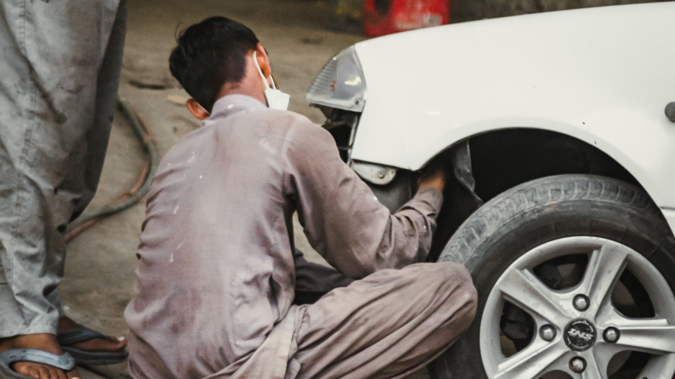 a boy cleaning a car's wheel
