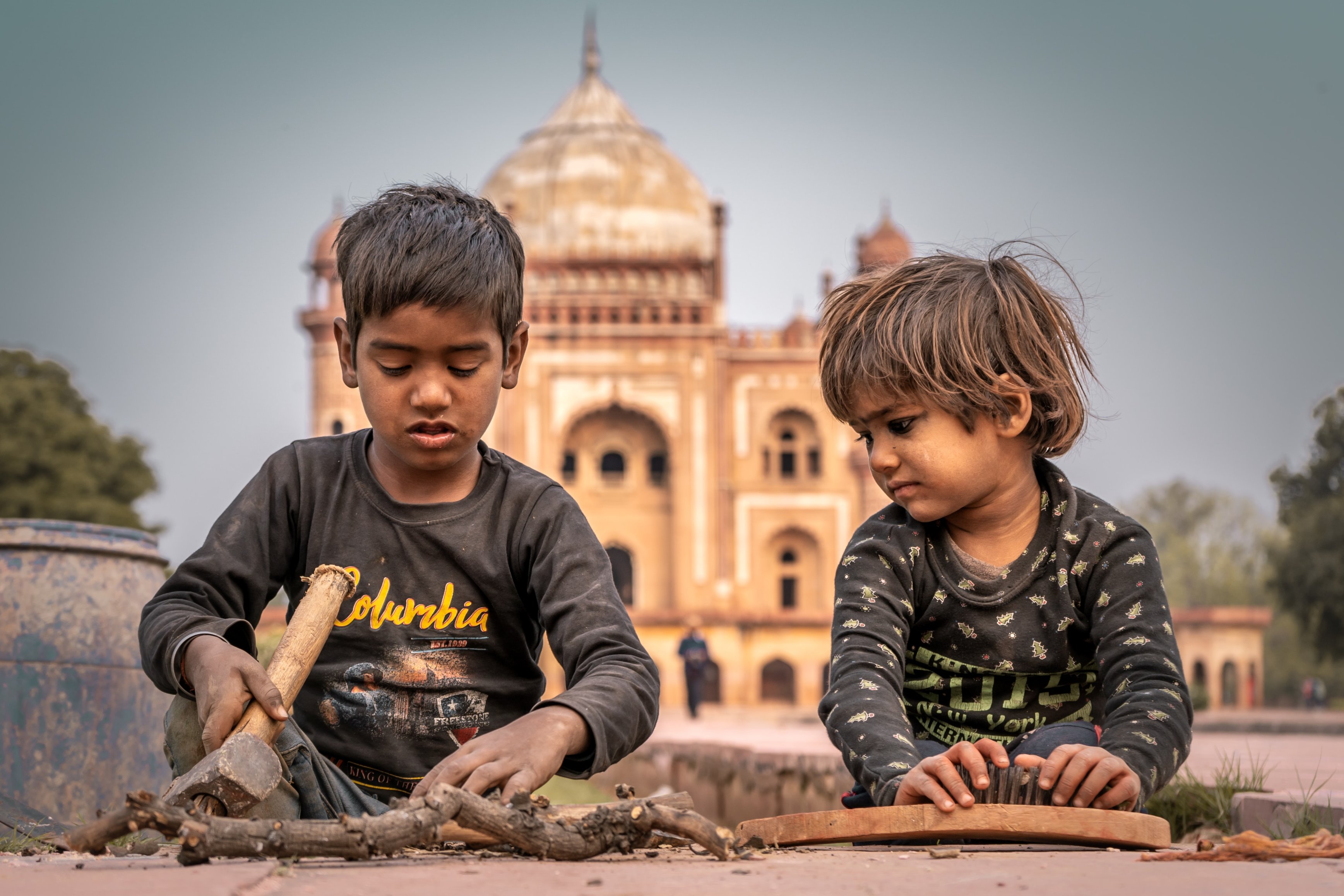 two children sitting in front of a building